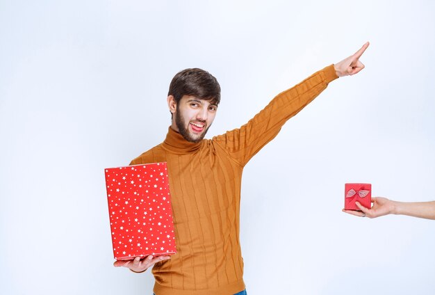 Man hat eine große rote Geschenkbox und bekommt auch eine kleine angeboten.