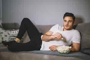 Kostenloses Foto man isst popcorn und fernsehen