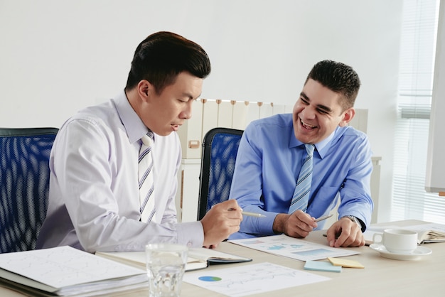 Man lacht über einen witz seines kollegen während der arbeit an einem gemeinsamen projekt