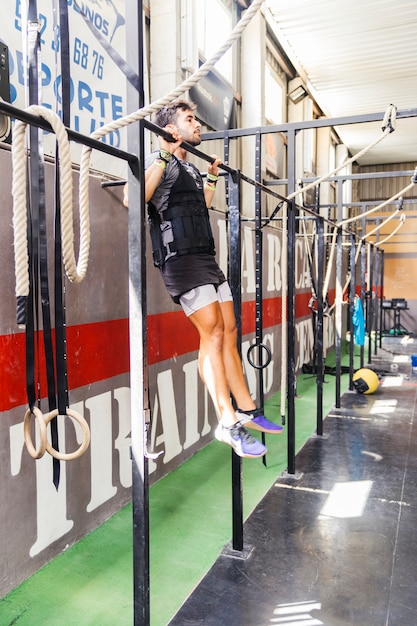 Kostenloses Foto man macht pull-ups im fitnessstudio