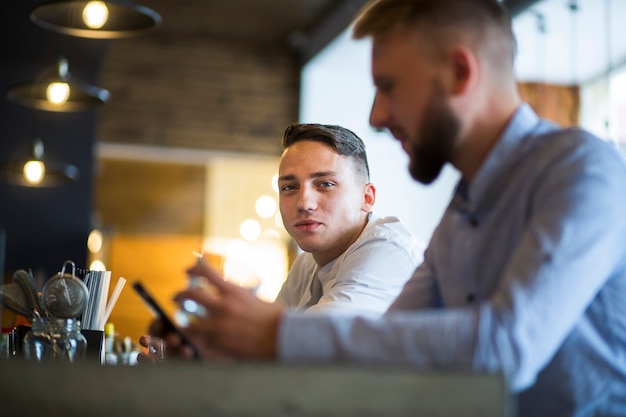 Man sitzt mit seinem Freund in der Bar