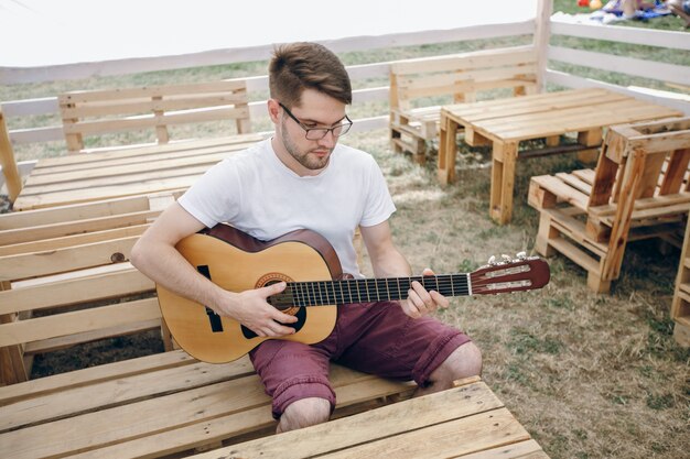 Man spielt Gitarre auf Holztischen