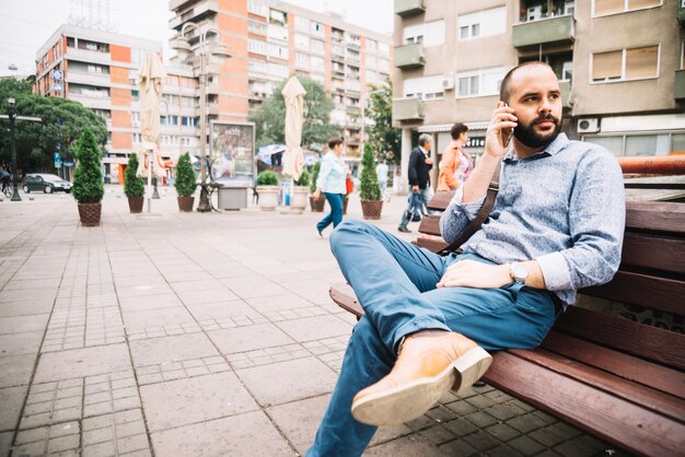 Man spricht Telefon auf der Bank