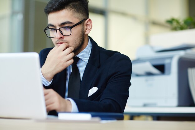 Manager, der mit Laptop im Büro arbeitet