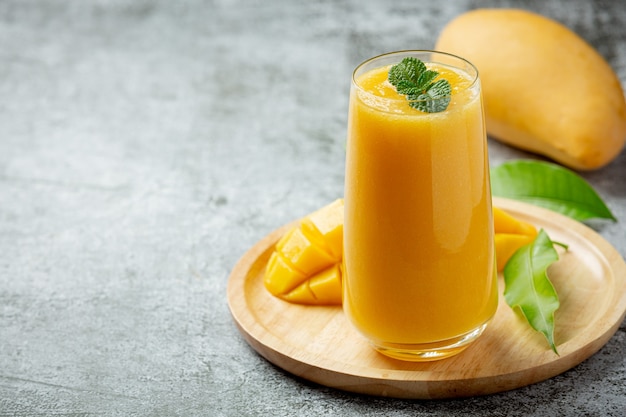 Mangosaft im Glas auf dunkler Oberfläche