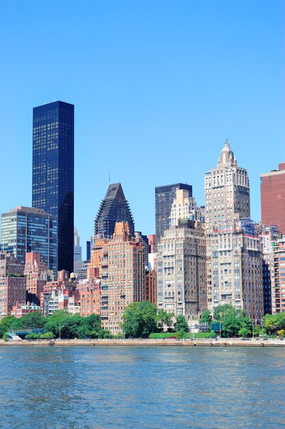 Manhattan Midtown Skyline Panorama über den East River mit städtischen Wolkenkratzern und blauem Himmel in New York City