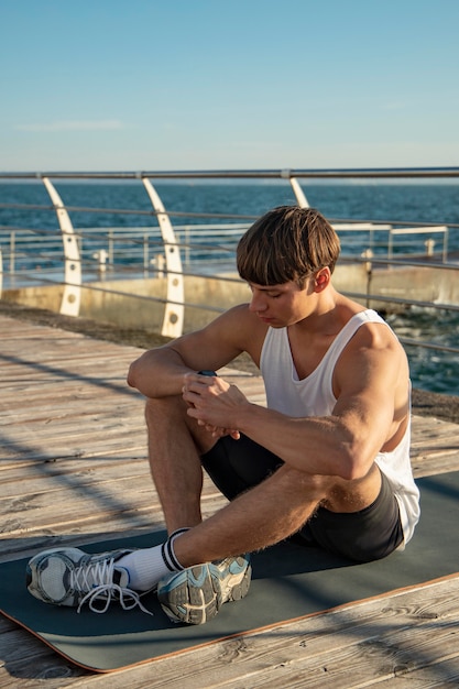 Mann am strand im trägershirt