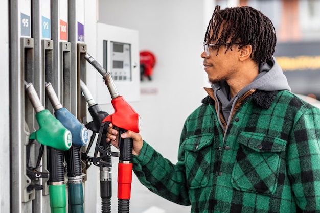 Kostenloses Foto mann an der tankstelle mit dem auto