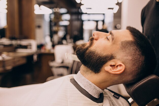 Mann an einem Friseursalon, der Haarschnitt und Bartschnitt tut