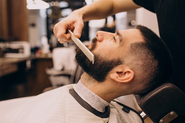 Mann an einem Friseursalon, der Haarschnitt und Bartschnitt tut