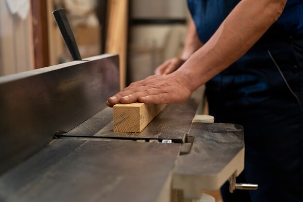 Mann arbeitet in seiner Holzwerkstatt mit Werkzeugen und Geräten