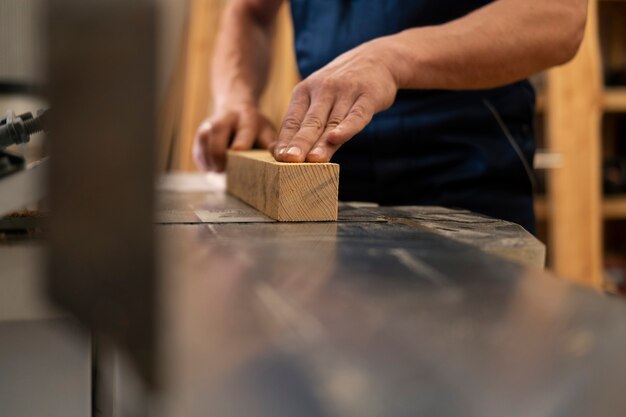 Mann arbeitet in seiner Holzwerkstatt mit Werkzeugen und Geräten