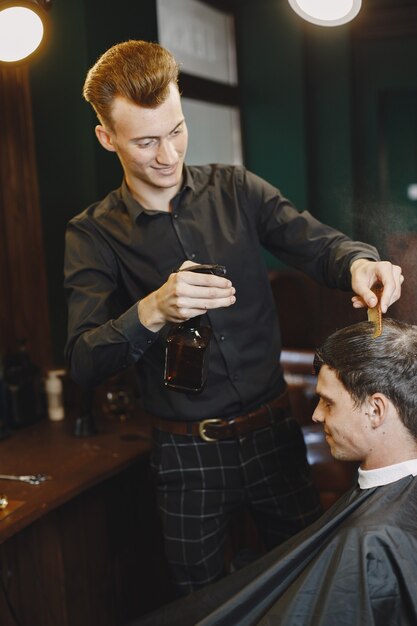 Mann arbeitet mit Haaren. Friseur mit einem Kunden.