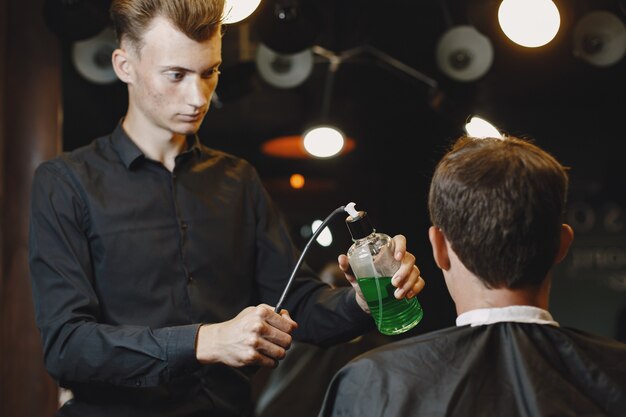 Mann arbeitet mit Haaren. Friseur mit einem Kunden.