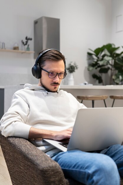 Mann arbeitet von zu Hause aus in der Küche mit Laptop