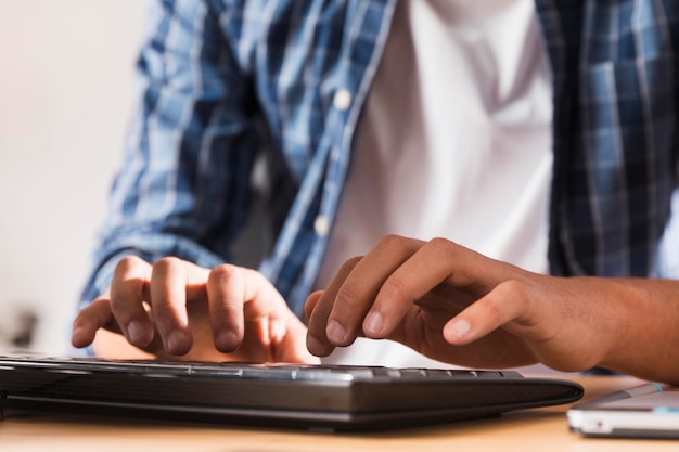 Mann arbeitet, während er eine Tastatur benutzt