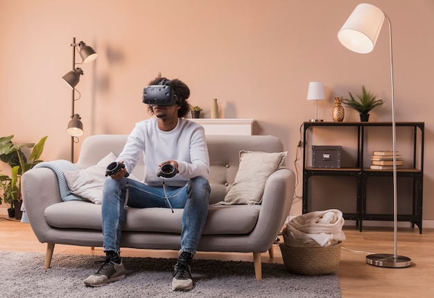 Mann auf Couch mit virtuellem Kopfhörer