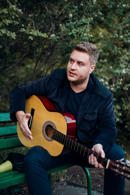 Mann auf der Bank, die Gitarre spielt