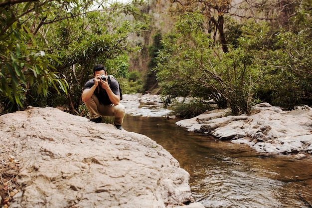 Mann auf Felsen am Fluss