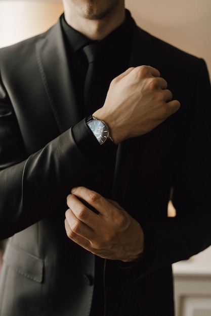 Kostenloses Foto mann befestigt einen manschettenknopf an seinem business-anzug