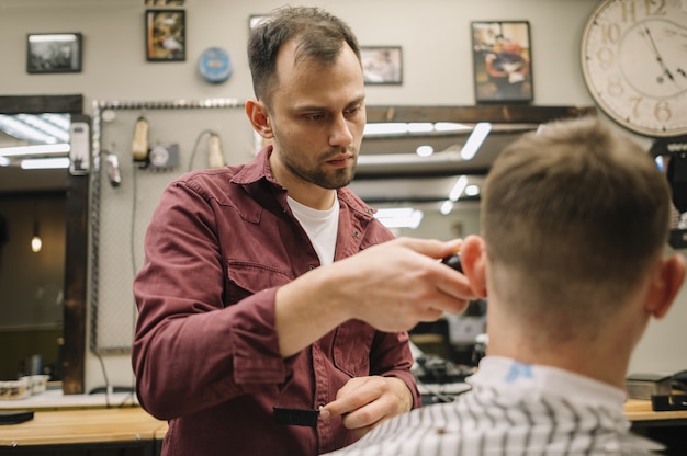 Mann bekommt einen Haarschnitt in einem Friseurladen