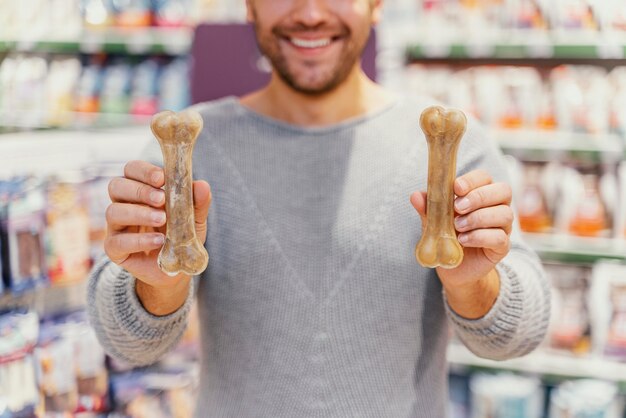 Mann bekommt einen Knochen für seinen Hund