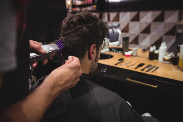 Mann bekommt seine Haare mit Trimmer geschnitten