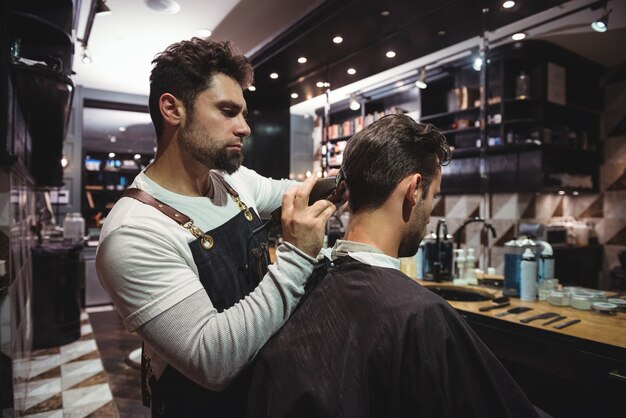 Mann bekommt seine Haare mit Trimmer geschnitten