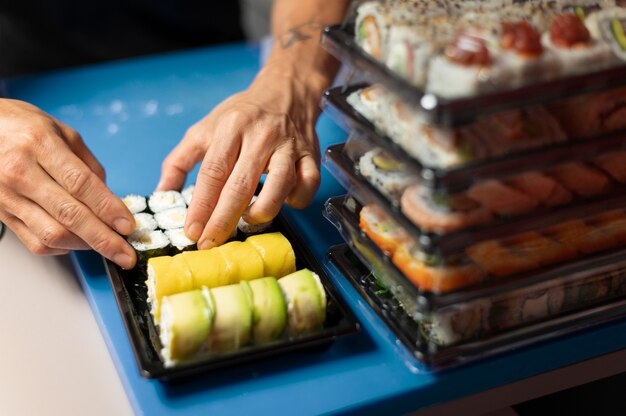 Mann bereitet eine Sushi-Bestellung zum Mitnehmen vor