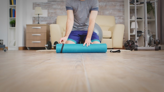 Mann bereitet sich auf Yoga im gemütlichen Wohnzimmer vor.