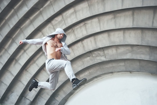 Mann beschäftigt mit Parkour, der auf dem Straßentraining springt.