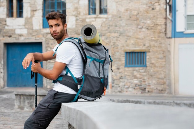 Mann, der allein in Mutriku reist, während er seine wichtigsten Sachen im Rucksack hat