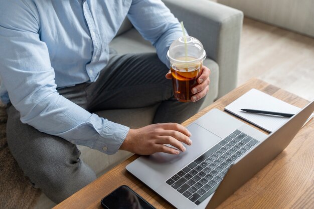 Mann, der am hohen Winkel des Laptops arbeitet