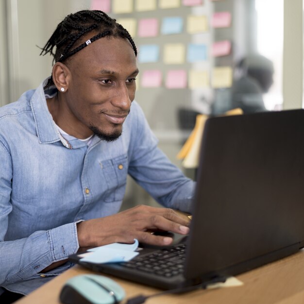 Mann, der am Laptop im Büro arbeitet