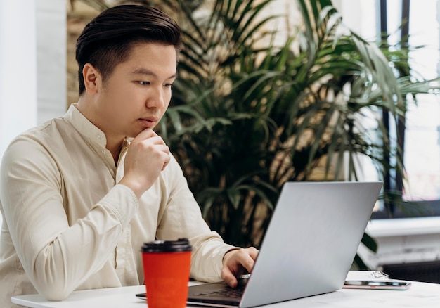 Mann, der am Laptop im Büro arbeitet