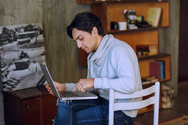 Mann, der am Laptop vom entfernten Heimbüro arbeitet. Foto in hoher Qualität