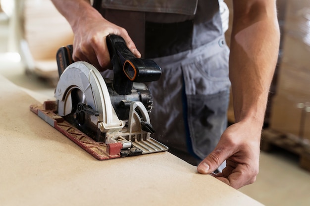 Mann, der am Schneiden von MDF-Platten arbeitet