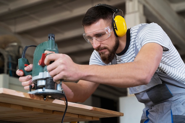 Kostenloses Foto mann, der am schneiden von mdf-platten arbeitet