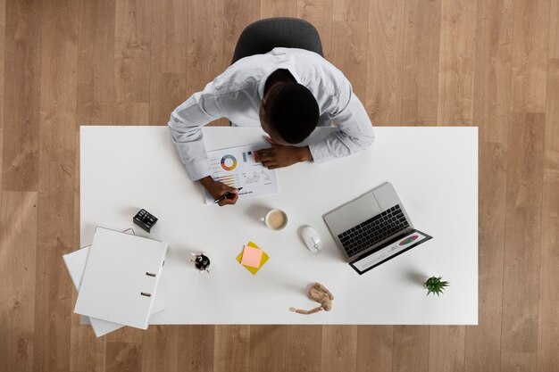 Mann, der am Schreibtisch arbeitet, liegt flach