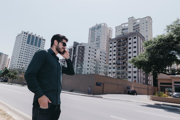 Kostenloses Foto mann, der am telefon auf straße spricht