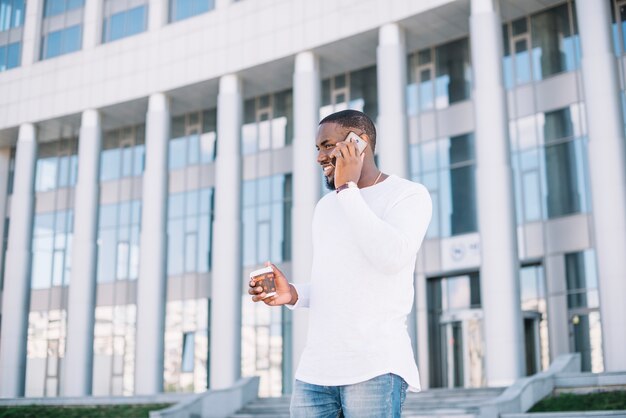 Mann, der am Telefon nahe Gebäude spricht