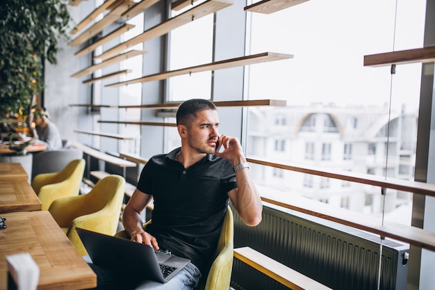 Mann, der am Telefon sitzt in einem Café spricht