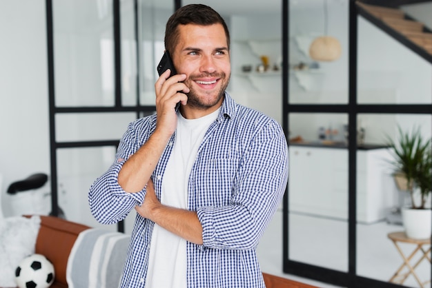 Mann, der am Telefon spricht und beim Sein glücklich weg schaut