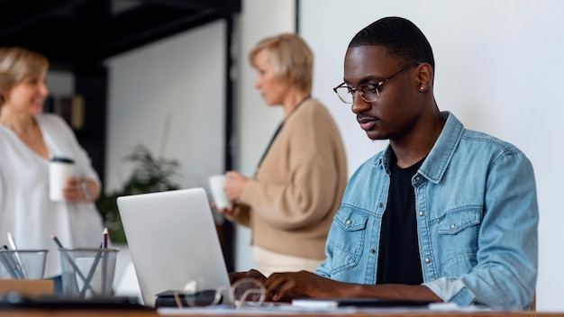 Mann, der an Laptop drinnen arbeitet