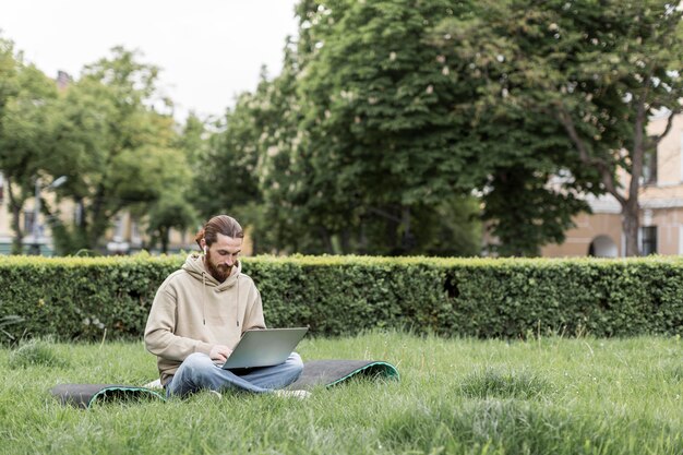 Mann, der an Laptop im Stadtpark arbeitet