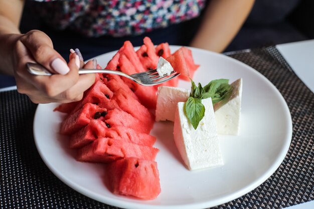 Mann, der aserbaidschanische Artgericht-Wassermelone mit Käseminze-Seitenansicht isst