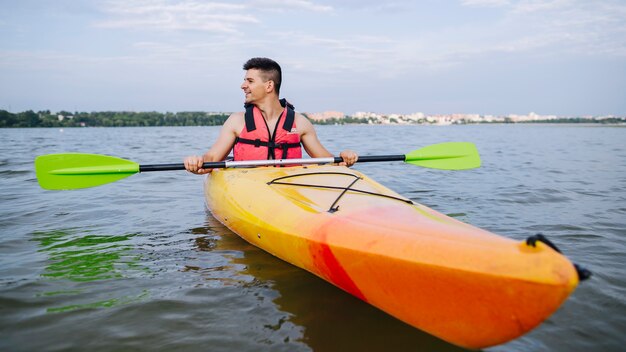 Mann, der auf Scenics See Kayak fährt