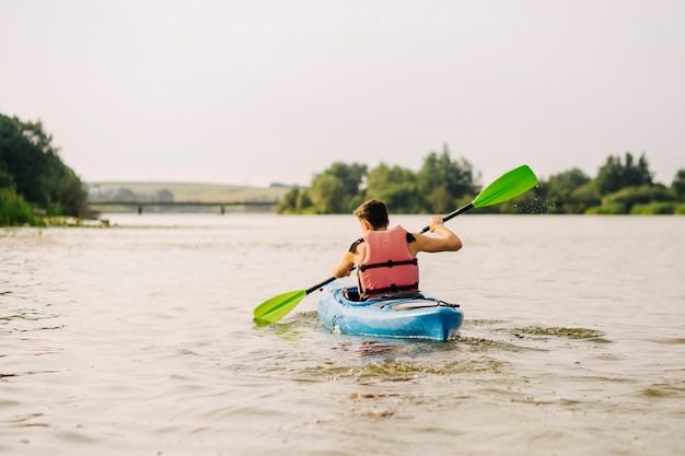 Kostenloses Foto mann, der auf see mit paddel kayaking ist