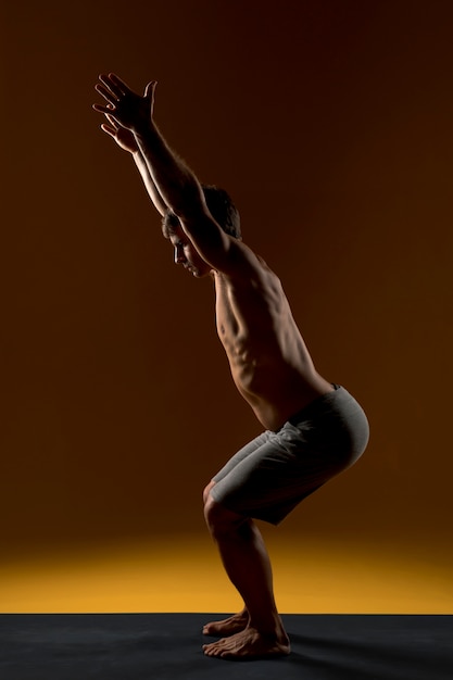 Kostenloses Foto mann, der auf yogamatte ausdehnt