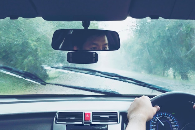 Mann, der Auto in starken Regenfällen fährt